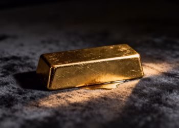 Lingot d'or brillant sur fond sombre.