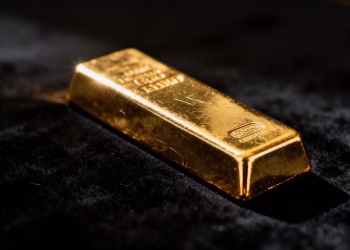Lingot d'or brillant sur fond sombre.