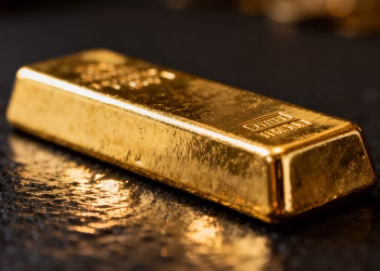Lingot d'or brillant sur fond sombre.