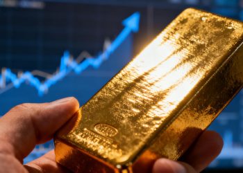 Main d'or tenant une barre d'or, avec un graphique flou.