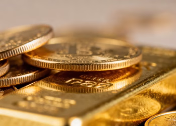 Pile de pièces et lingots d'or brillants.