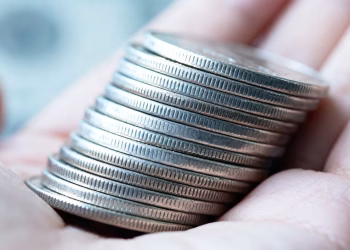 Main d'une personne tenant des pièces d'argent.