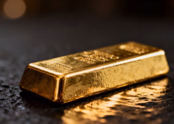 Lingot d'or brillant sur fond sombre.