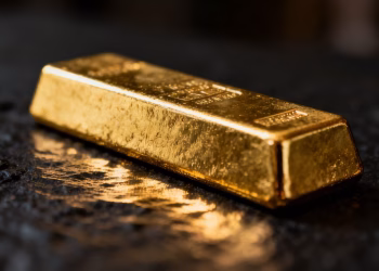 Lingot d'or brillant sur fond sombre.