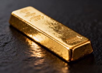 Lingot d'or brillant sur fond sombre.