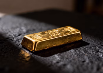 Lingot d'or brillant sur fond sombre.