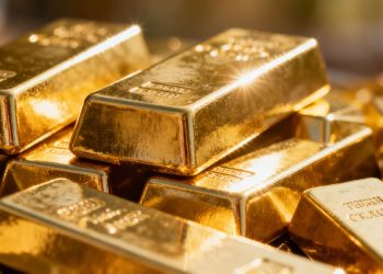 Lingots d'or brillants sous la lumière.