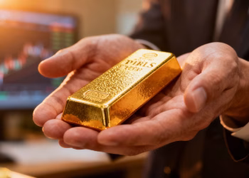 Mains tenant une barre d'or, mentor trading