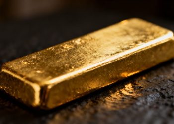 Lingot d'or brillant sur fond sombre.