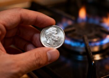 Main d'une personne tenant une pièce en argent.