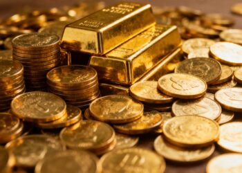 Lingots et pièces d'or brillants empilés.