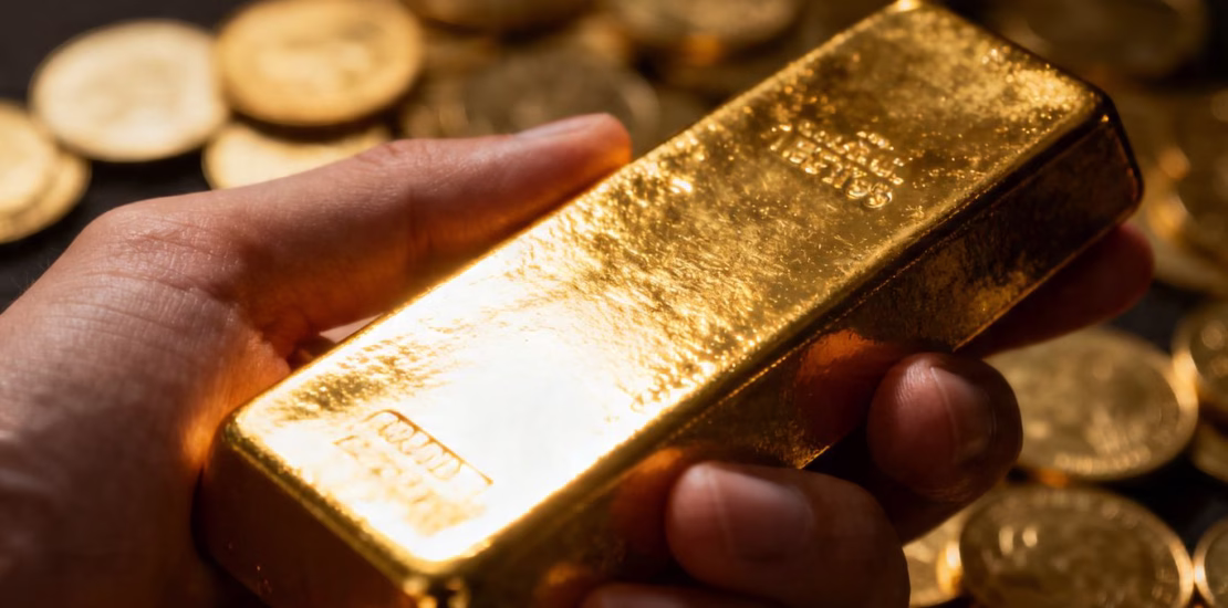 Main d'une personne tenant une barre d'or