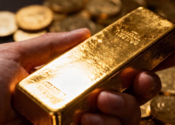 Main d'une personne tenant une barre d'or