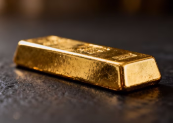 Lingot d'or brillant sur fond sombre.