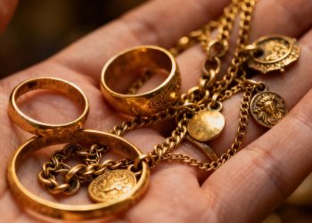 一只手拿着古董金饰。