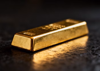 Lingot d'or brillant sur fond sombre.