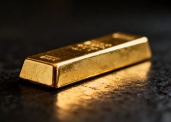 Lingot d'or brillant sur fond sombre.