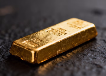 Lingot d'or brillant sur fond sombre.