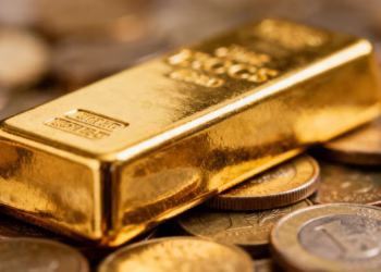 Lingot d'or sur une pile de pièces de monnaie.