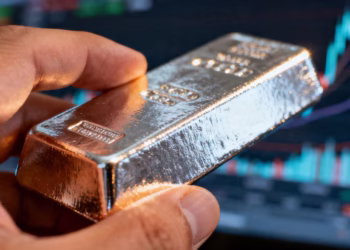 A person's hand holding a silver bar.