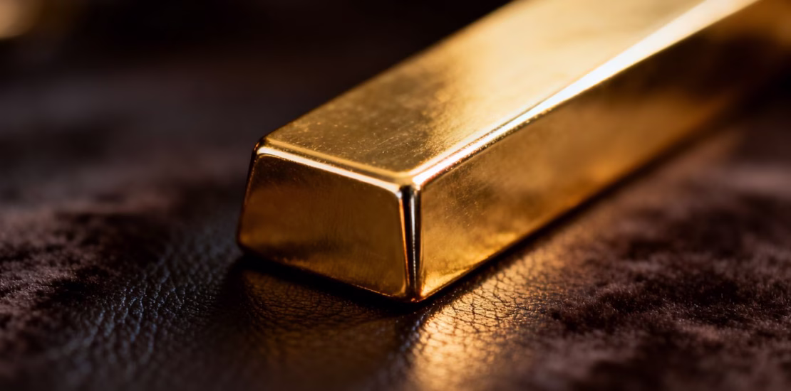 Lingot d'or sur fond sombre, reflet métallique.