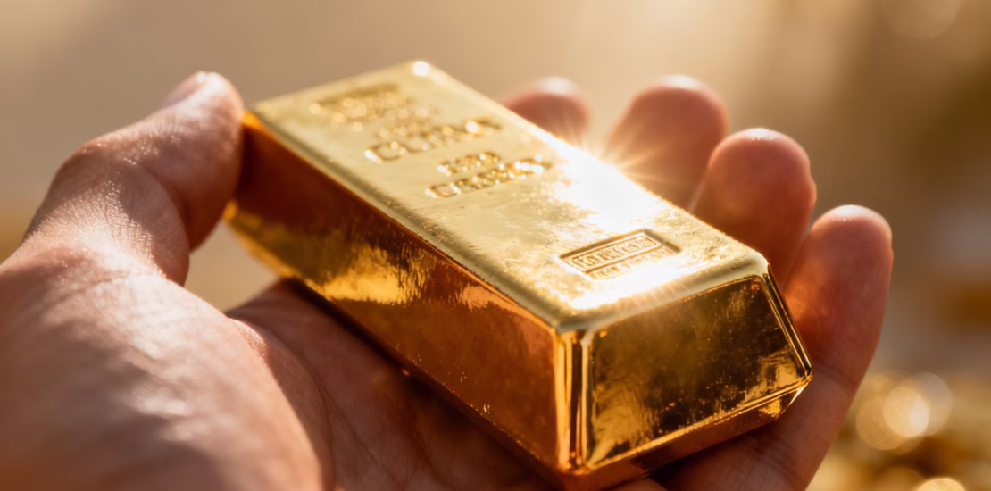 Main d'or tenant une barre d'or brillante