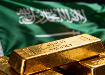 Lingot d'or devant le drapeau de l'Arabie saoudite.