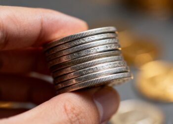 Main d'une personne tenant des pièces d'argent.