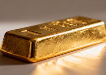 Shiny gold ingot, close-up, light reflection.