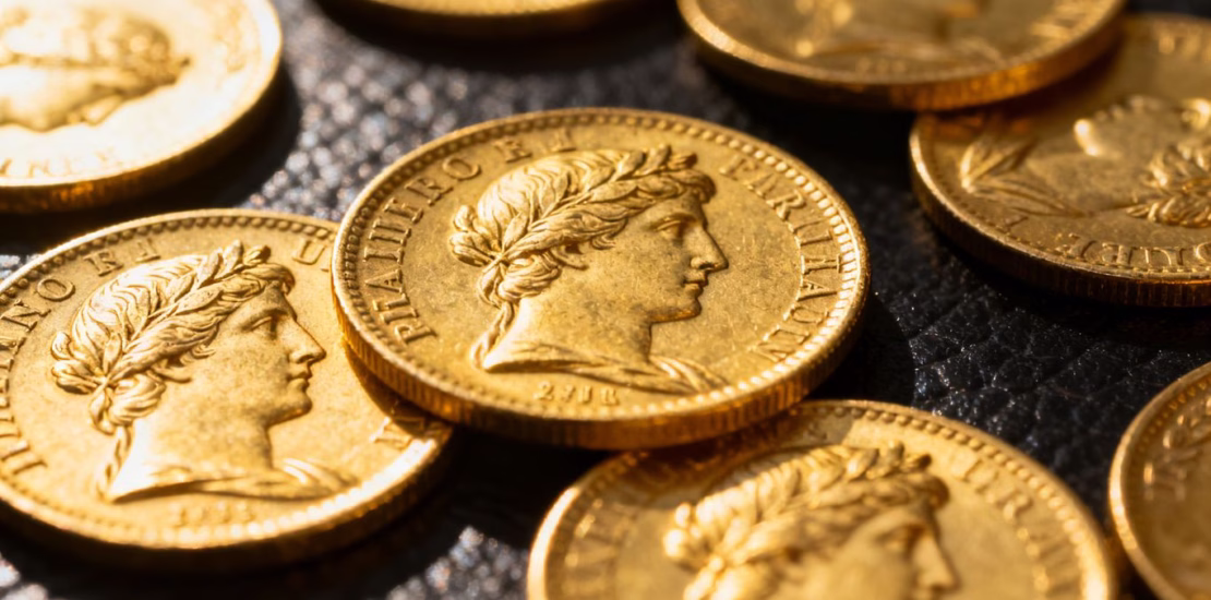 Pièces d'or françaises brillantes, gros plan, sur fond sombre.