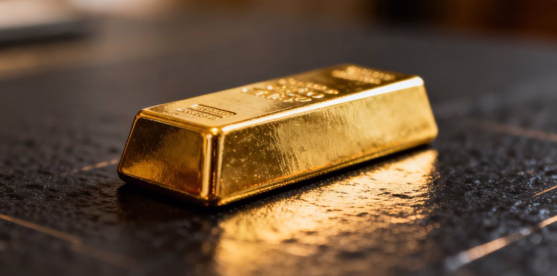 Lingot d'or brillant sur fond sombre.