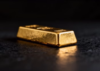 Lingot d'or brillant sur fond sombre.