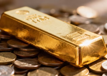 Lingot d'or sur des pièces, reflétant la lumière.