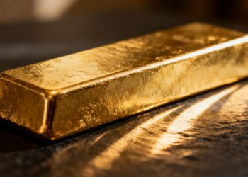 Lingot d'or brillant sur fond sombre.