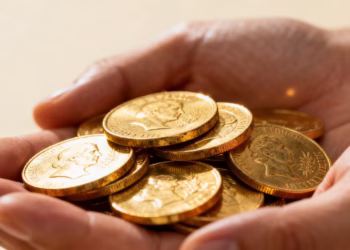 Mains tenant des pièces d'or brillantes