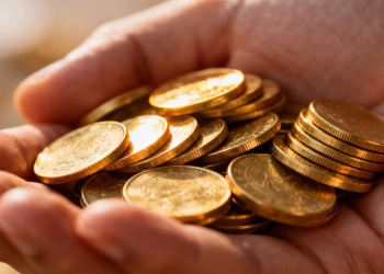 Main d'or tenant des pièces d'or