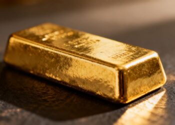 Lingot d'or brillant sur fond sombre.