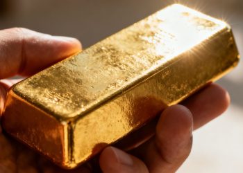 Main d'or tenant une barre d'or