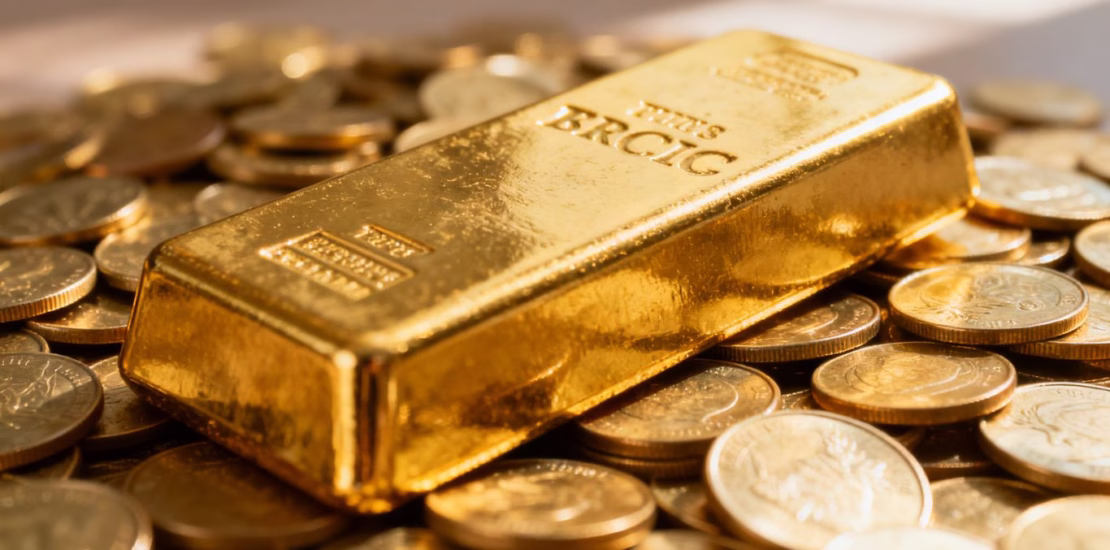 Lingots d'or et pièces d'or brillants sous la lumière.