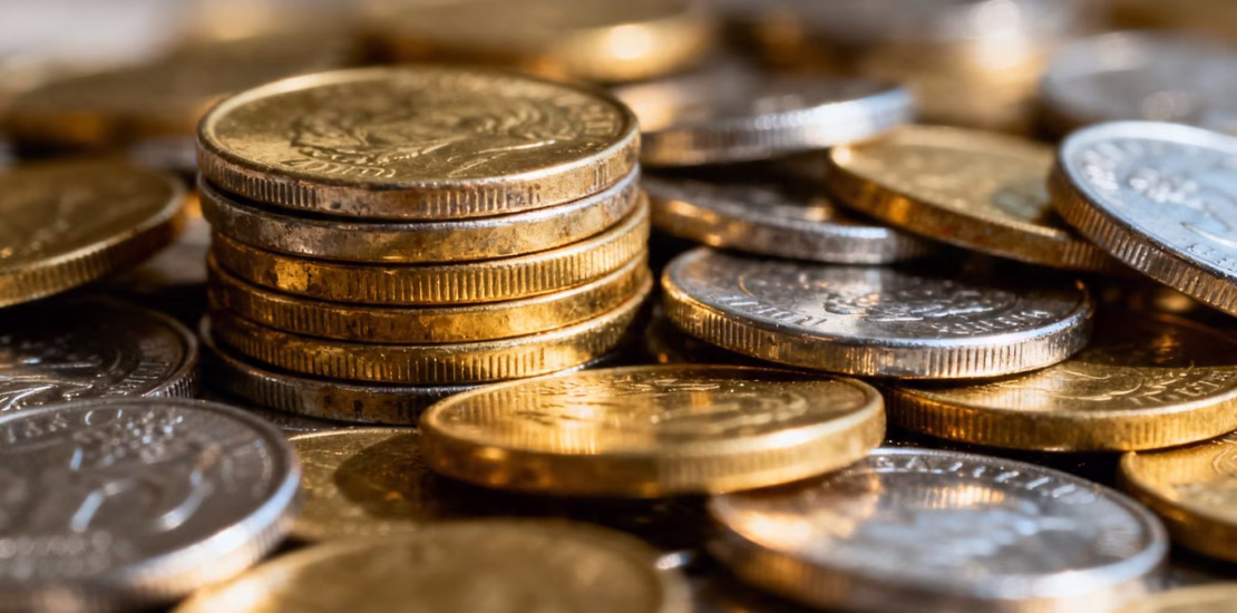 Pièces d'or et d'argent brillantes empilées.