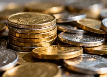 Pièces d'or et d'argent brillantes empilées.