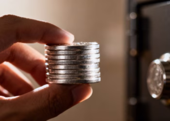 Main d'une personne tenant des pièces d'argent.