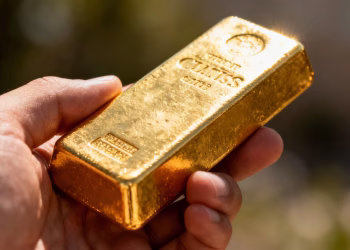 金手握着闪闪发光的金条。