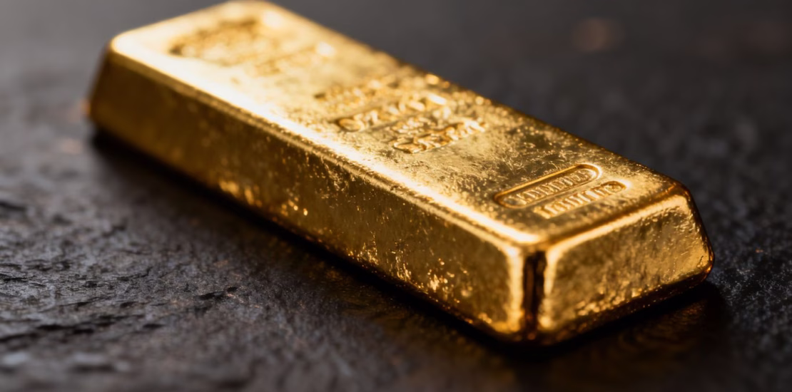 Lingot d'or brillant sur fond sombre.