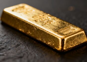 Lingot d'or brillant sur fond sombre.