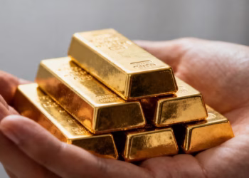 Mains tenant des lingots d'or brillants.