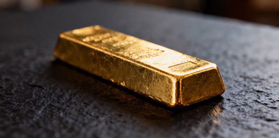 Lingot d'or brillant sur fond sombre.
