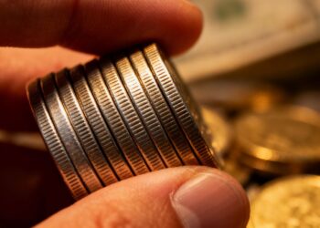 Main d'une personne tenant des pièces d'argent.