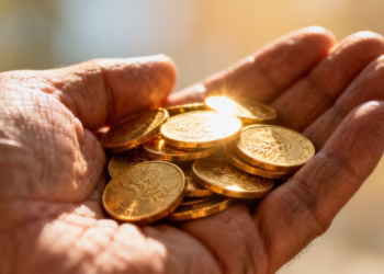 Main d'or tenant des pièces d'or.