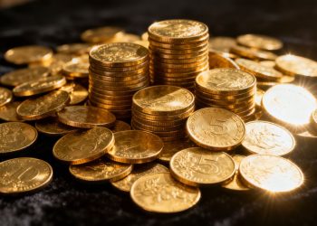 Pièces d'or brillantes empilées et dispersées.